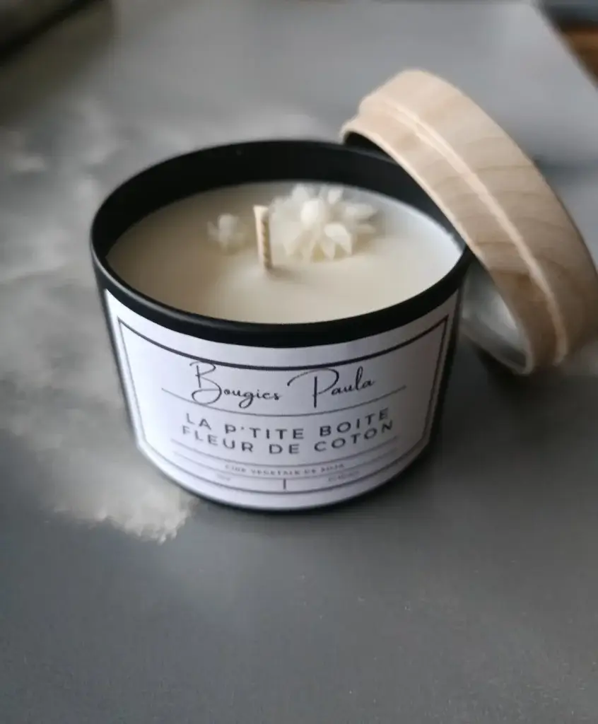 Bougie parfumée dans un pot en fer noir disposée sur un fond faisant apparaitre une vague pendant la tempête.