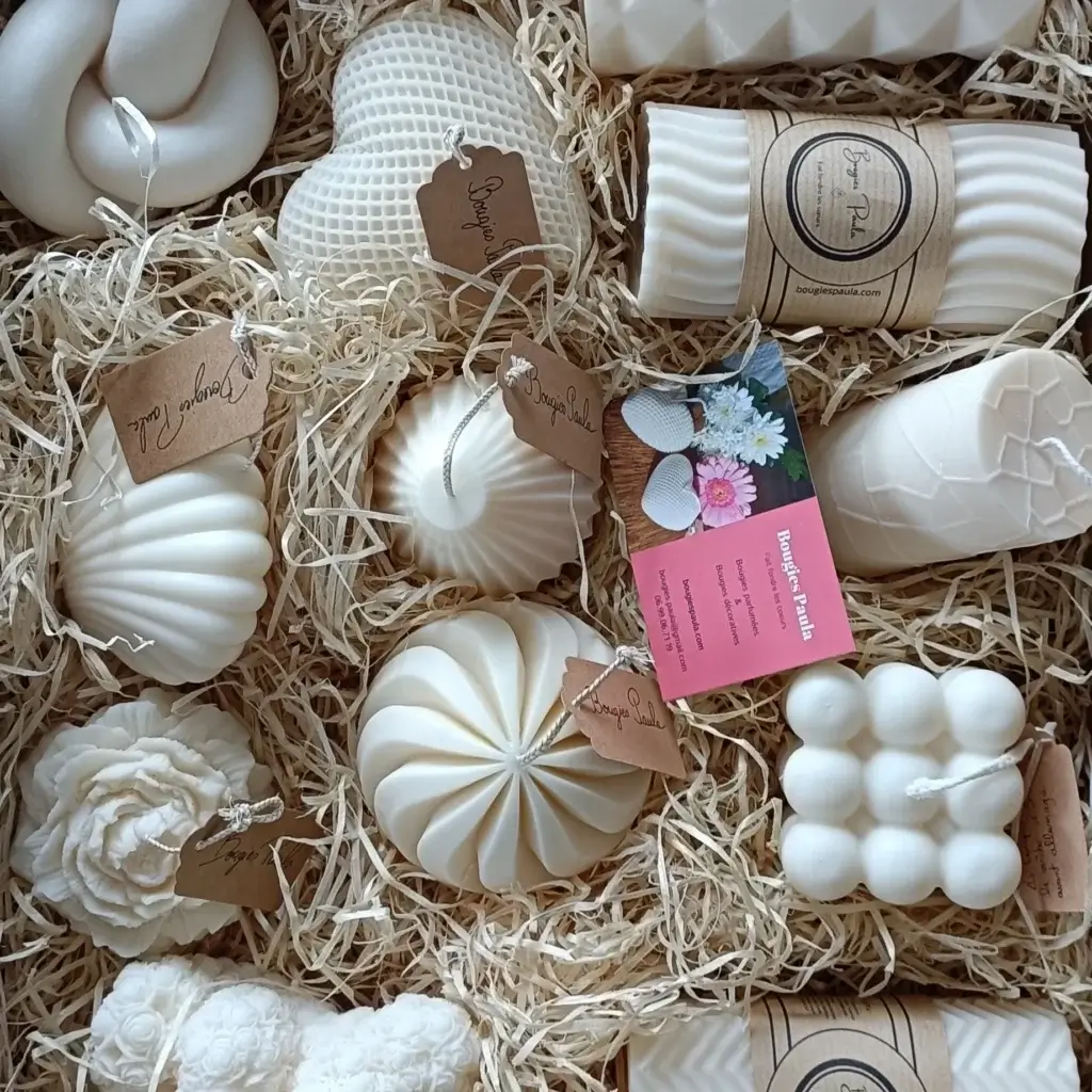 Ensemble de bougies décoratives disposées sur un lit de paille.