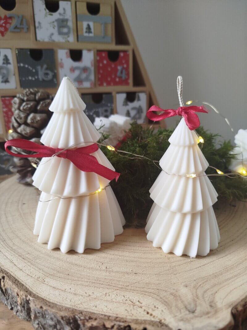 Bougies en forme de sapin de Noël arboré d'un petit de soie rouge.