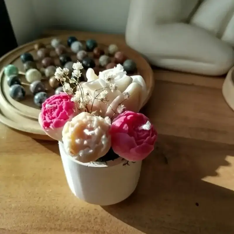 Vue éloignée du bouquet de bougies dans un contenant en plâtre.