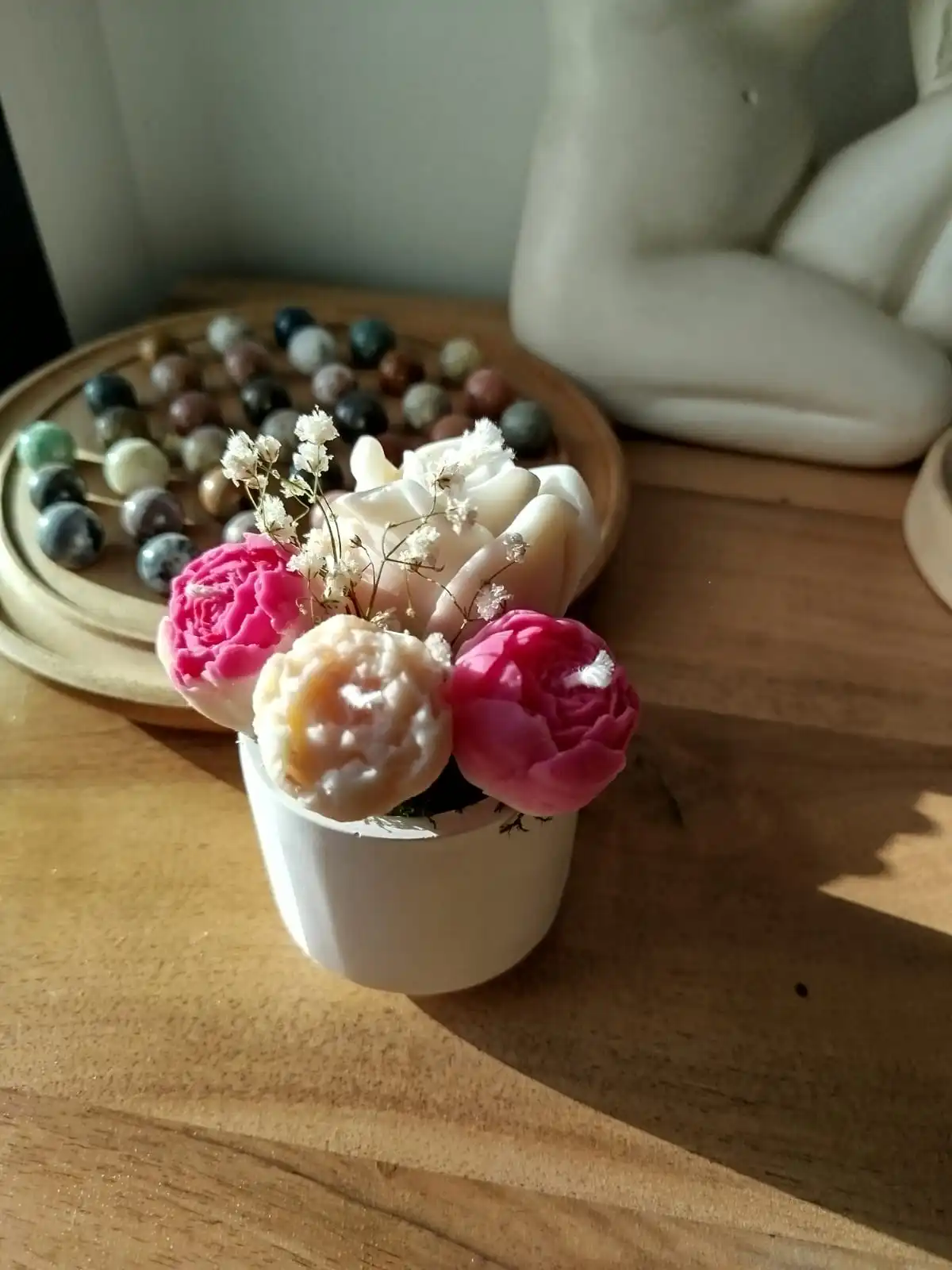 Vue éloignée du bouquet de bougies dans un contenant en plâtre.