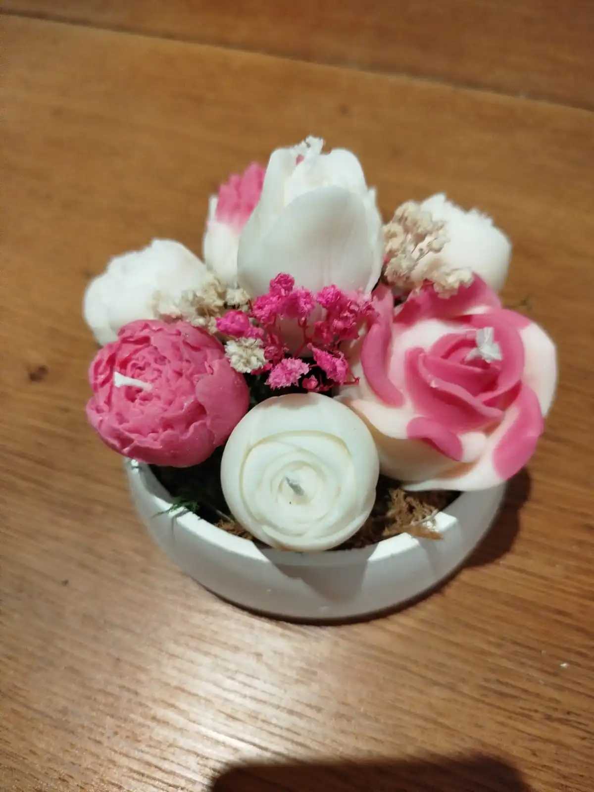 Elegance d'une composition de bougies en forme de fleur de couleur blanche et fushia.