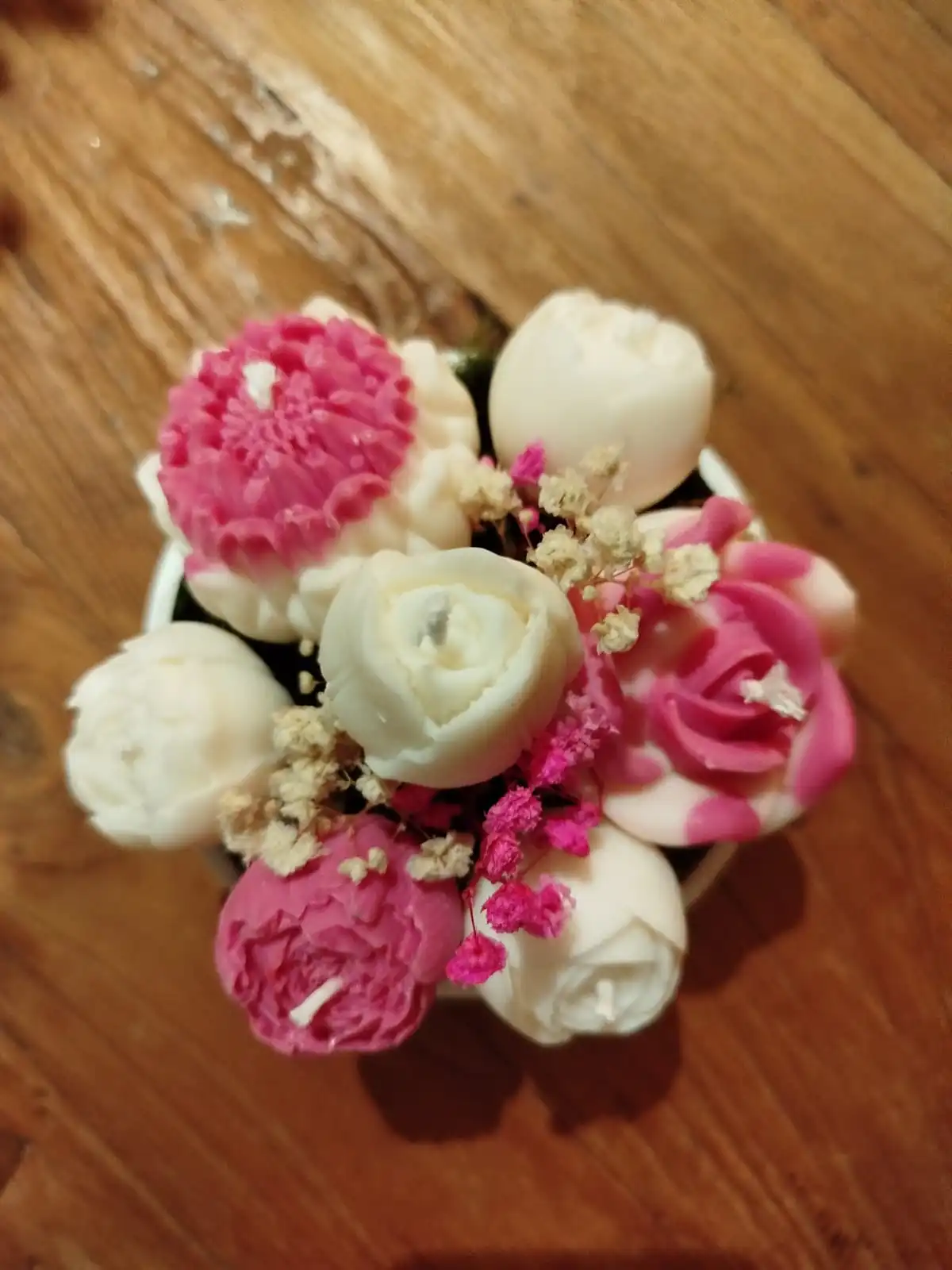 Des bougies en forme de fleurs de couleur fushia.