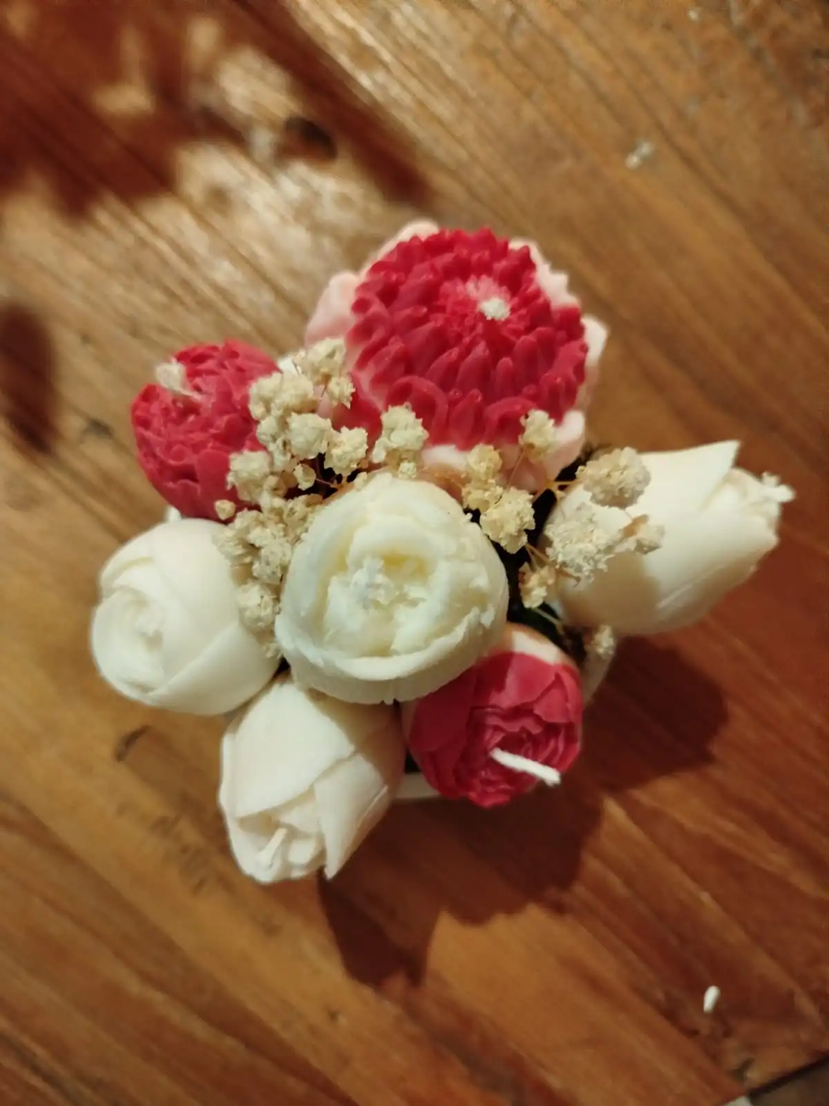 Bouquet de bougies en forme de fleurs de couleur rouge rose.