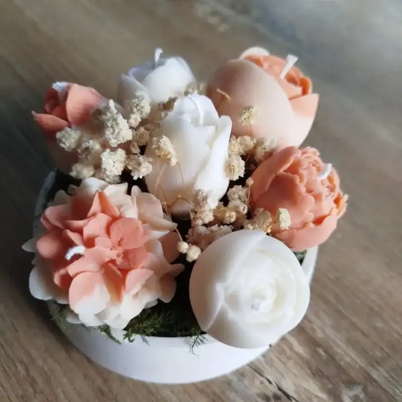 Composition florale composée de bougies de couleur terracotta, un mélange de tulipes, hortensias et renoncules.