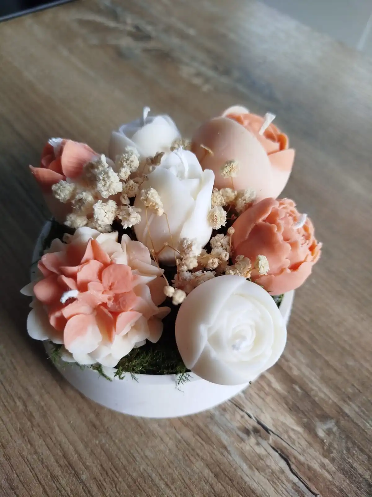 Composition florale composée de bougies de couleur terracotta, un mélange de tulipes, hortensias et renoncules.