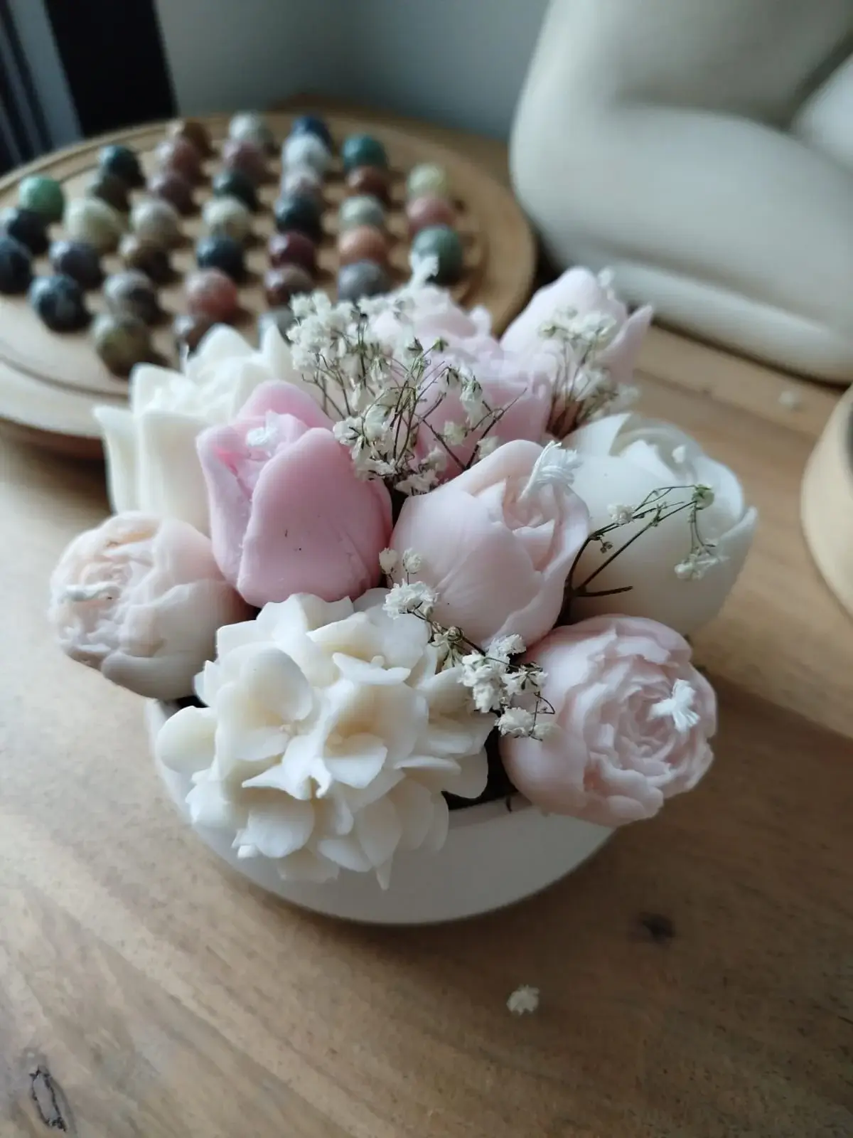 Composition de bougies florales dans les tons rose et blanc.