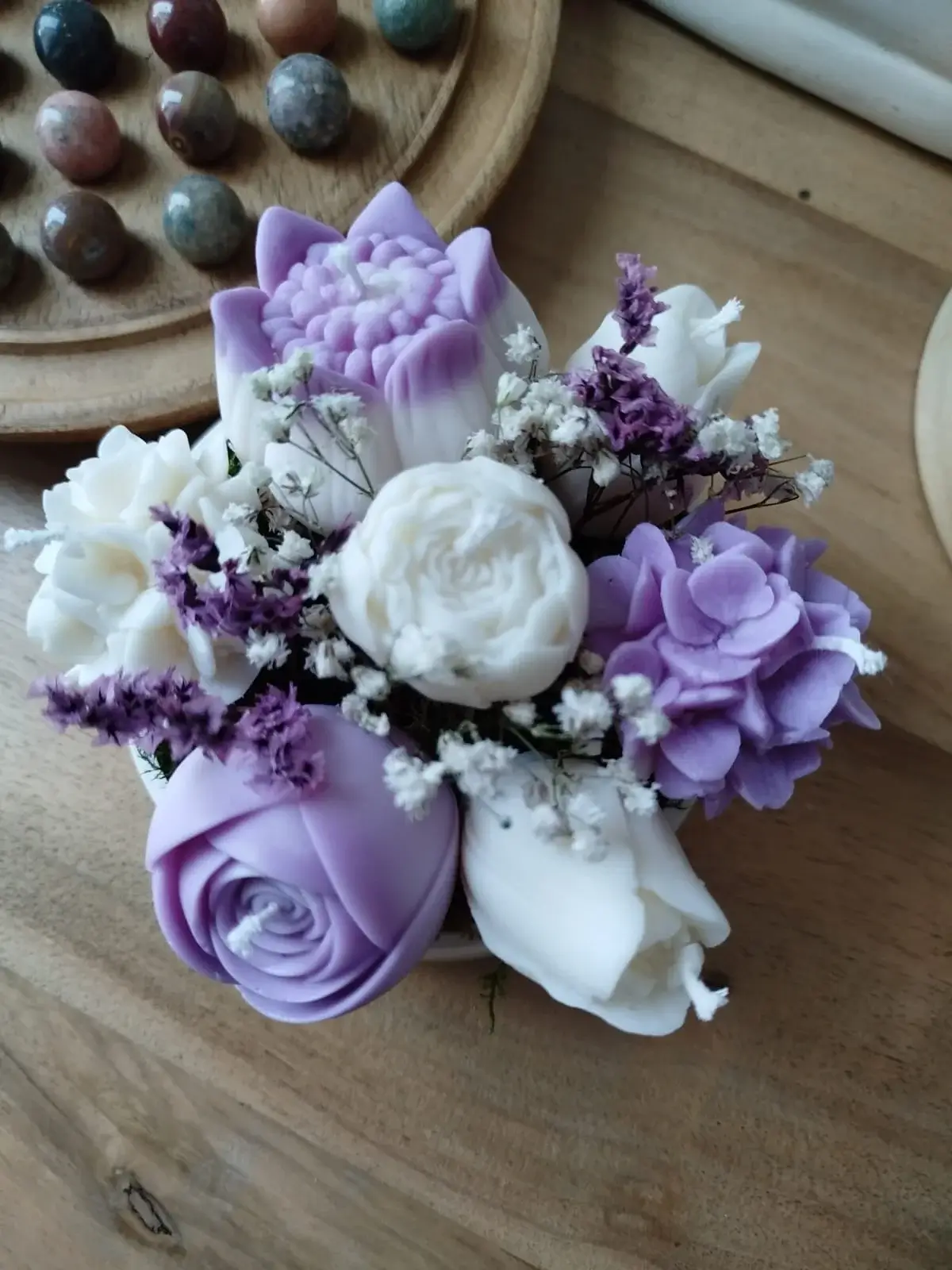 Composition florale de bougies en forme de fleurs de couler parme et blanc.