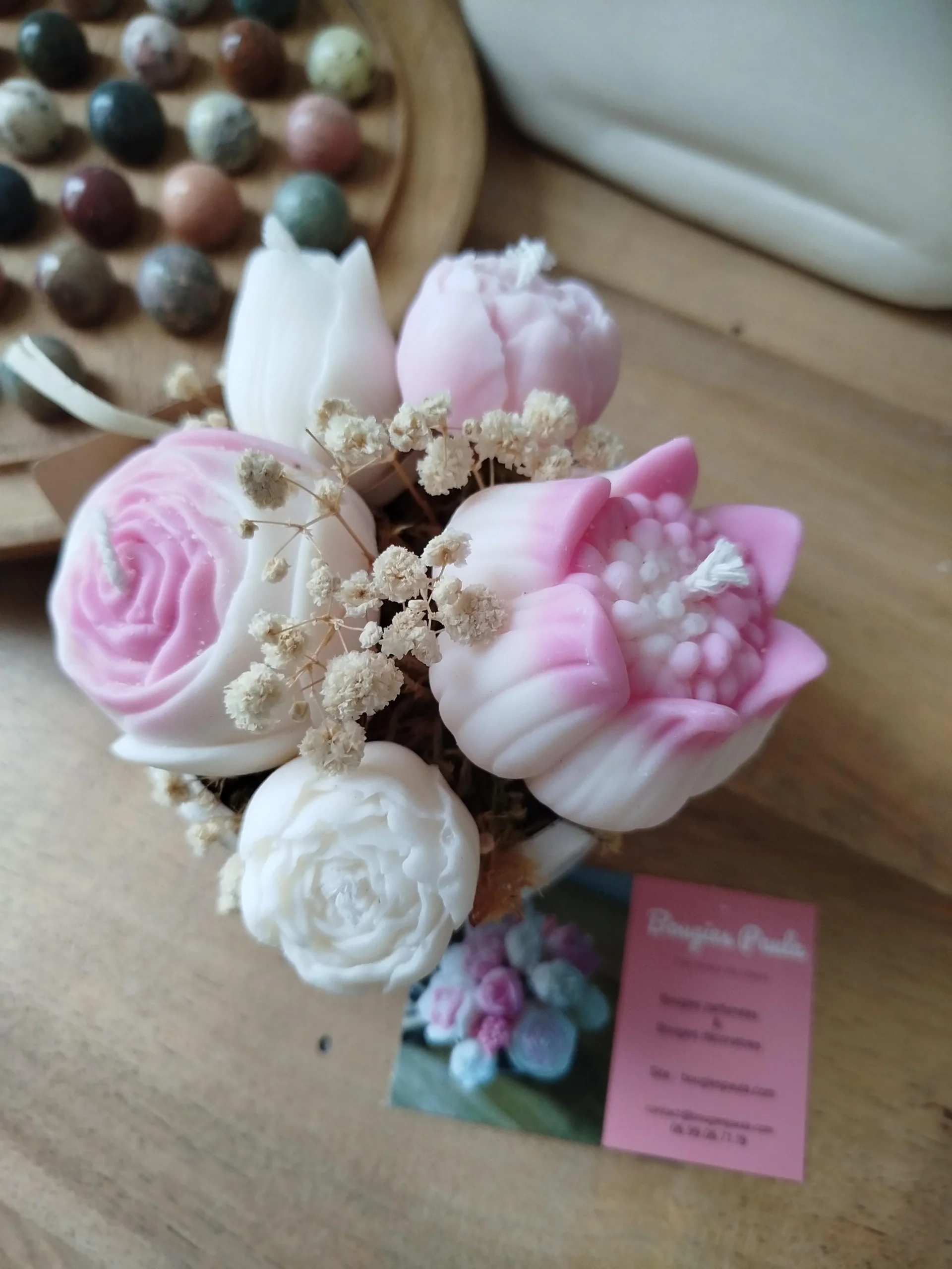 Composition florale de couleur fleurs roses dans une coupelle en platre.