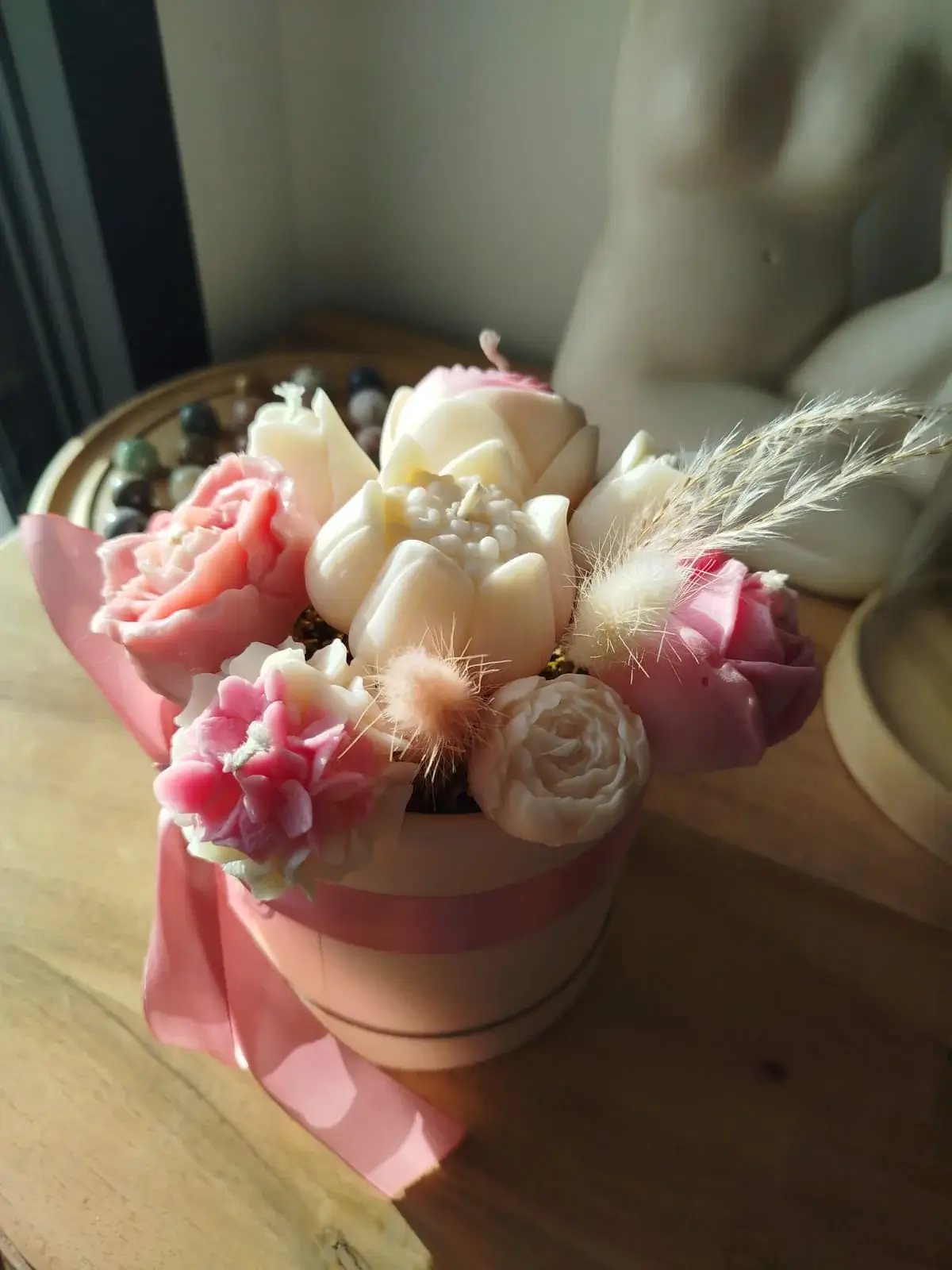 Bouquet floral en bougies dans boîte rose.
