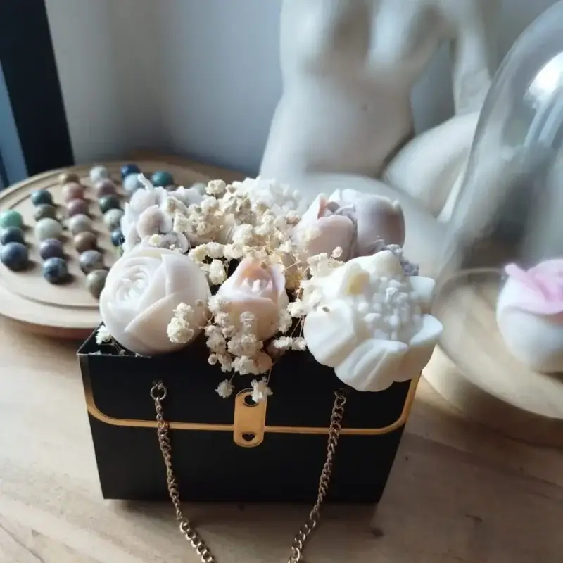 Sac noir contenant des bougies de couleur beige et cire naturelle.