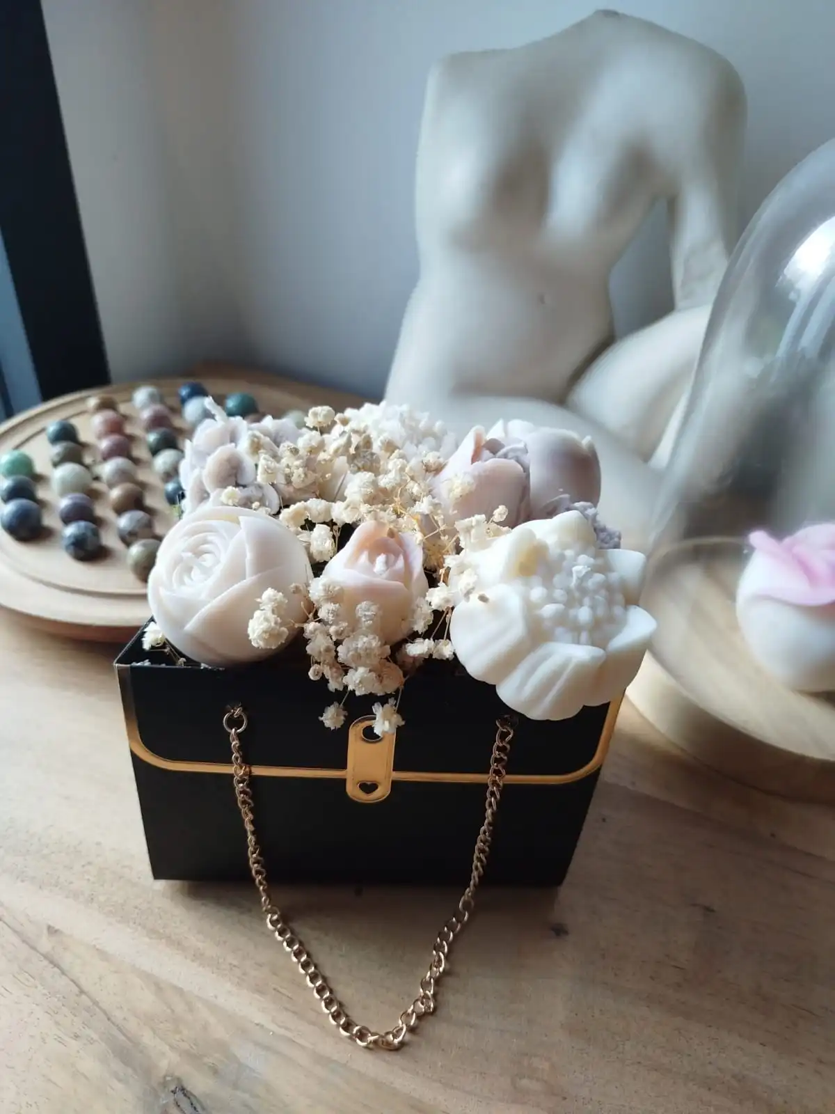 Sac noir contenant des bougies de couleur beige et cire naturelle.