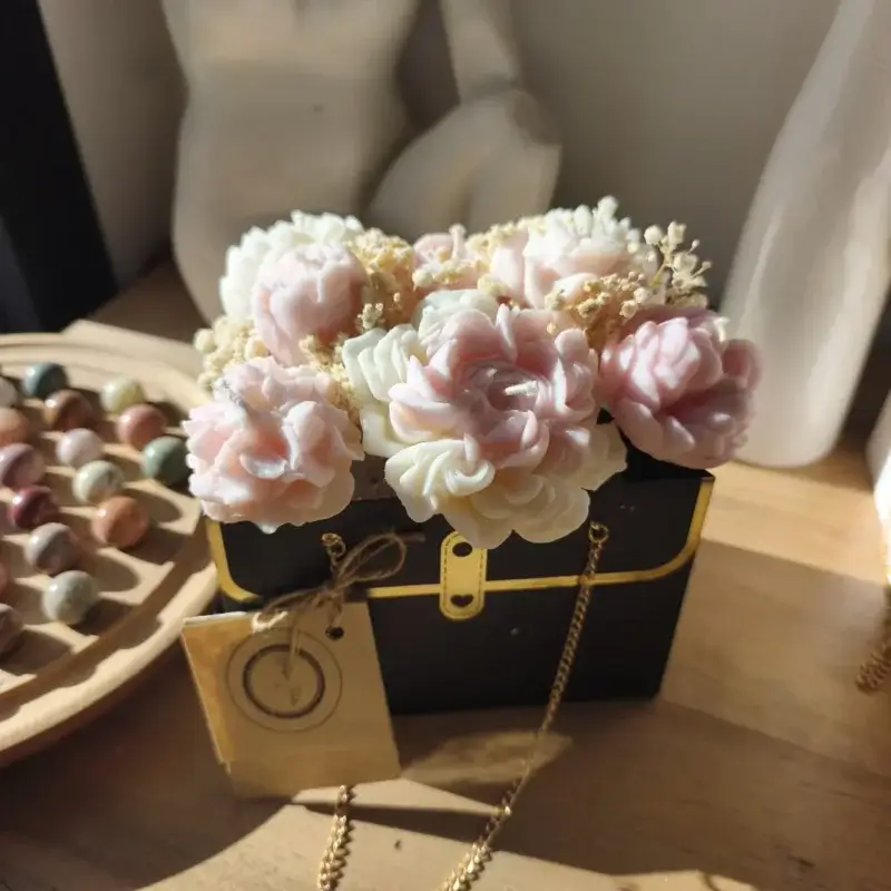 Bouquet de bougies rose poudré dans son sac noir.